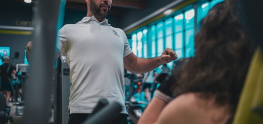 Sesión de entrenamiento en el gimnasio con un entrenador personal, enfocada en el rendimiento y el bienestar físico.