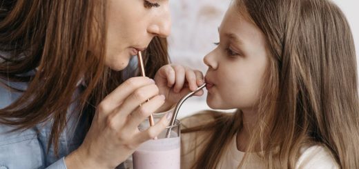 A mother and daughter sharing a strawberry milkshake indoors, depicting love and bonding.